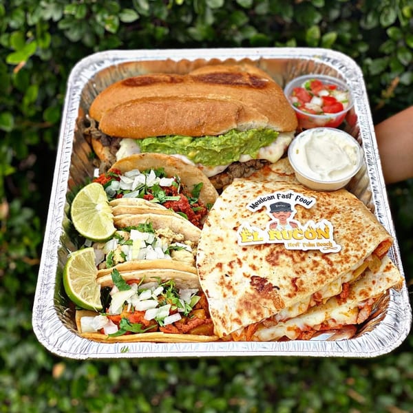 El Rucon Mexican food platter with tacos, quesadillas, a torta, pico de gallo, and sour cream.