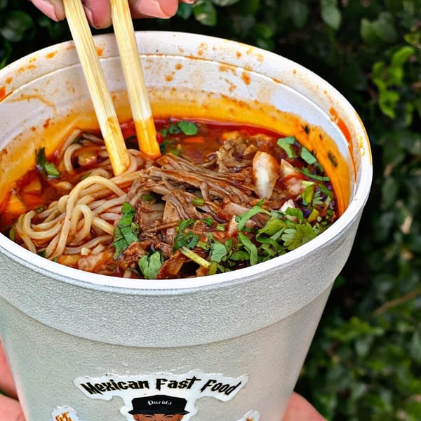 El Rucon's Mexican birria ramen with shredded meat, noodles, and cilantro in a styrofoam cup.